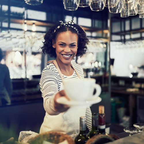 smiling-barista-holding-up-a-fresh-cup-of-coffee